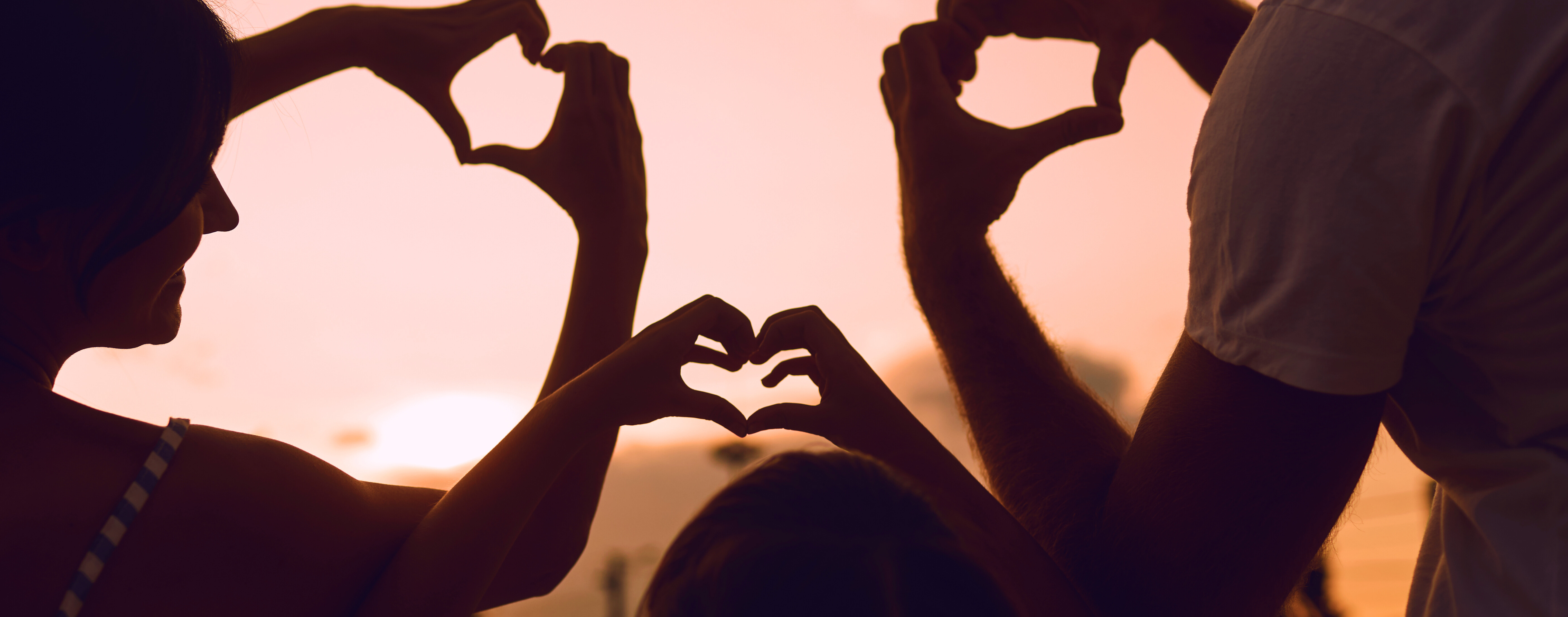 Family making heart shape with their hands
